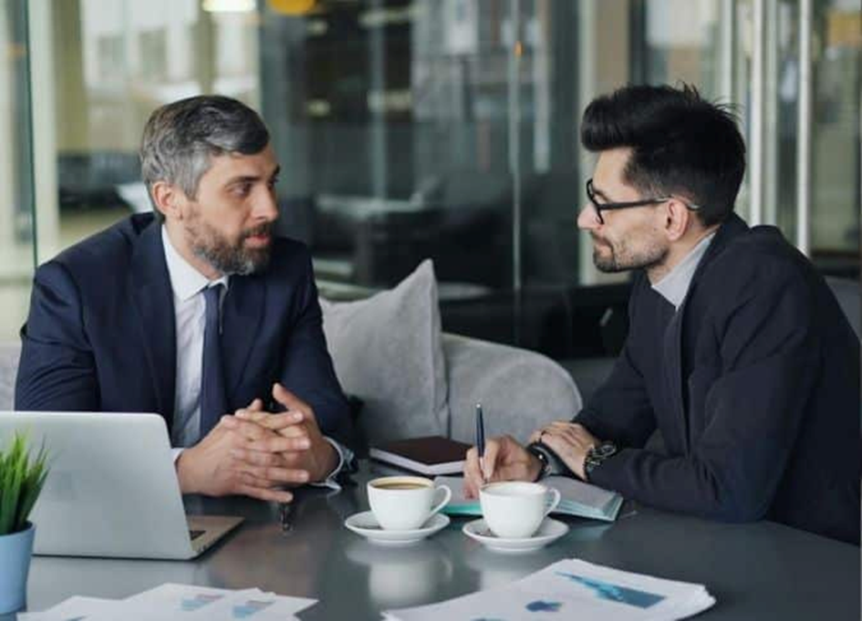 Ein Manager und ein Mitarbeiter reden miteinander